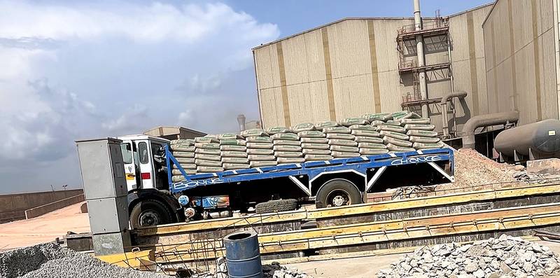 Camion Tokoos chargé de sacs de ciment devant l'usine